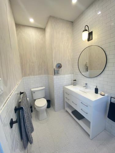 ein Badezimmer mit einem Waschbecken, einem WC und einem Spiegel in der Unterkunft Rooster Beach - Hope Town, Elbow Cay in Lubbers Quarters Cay
