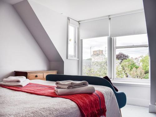 a bedroom with a bed and a large window at Isabel's House in St. Andrews