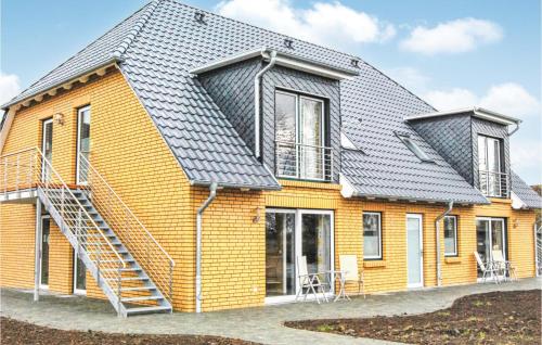 a yellow house with a metal roof at Fewo Wasserburg Turow in Kaschow