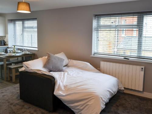 um quarto com uma cama com lençóis brancos e almofadas em Apartment 1 The Boardwalk - Uk31781 em Great Yarmouth