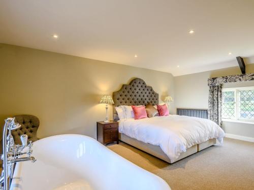 a bedroom with a large bed and a bath tub at The Apple Store - Uk32623 in Swannington