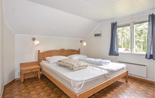 Schlafzimmer mit einem Bett mit weißer Bettwäsche und Kissen in der Unterkunft Cozy Home In rjng With Wifi in Hjällen