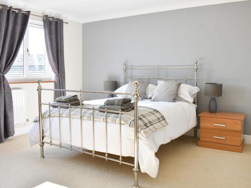 a bedroom with a metal bed with white sheets and pillows at Chapel House in Dearham