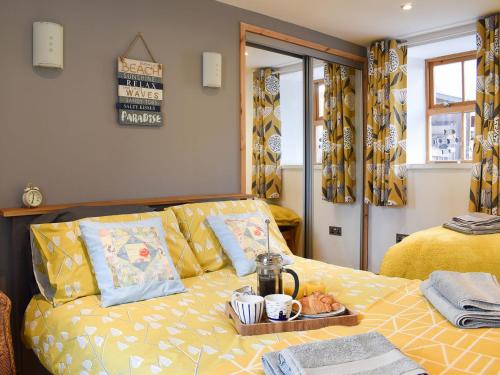 a living room with a yellow couch with a tray on it at Viaduct View in Cullen