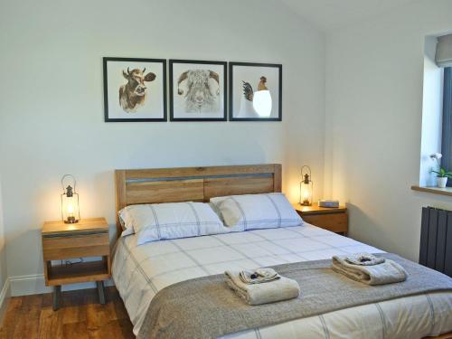 1 dormitorio con 1 cama y 3 cuadros en la pared en Harrys Den, en Chapel St. Leonards