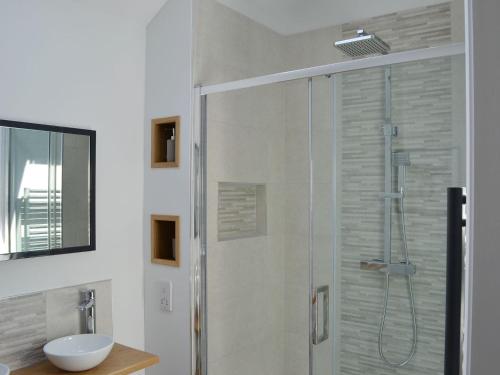 a bathroom with a glass shower with a sink at Harrys Den in Chapel Saint Leonards
