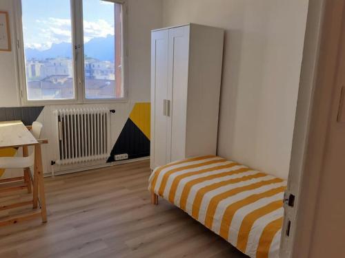 Schlafzimmer mit einem Bett, einem Schreibtisch und Fenstern in der Unterkunft Grenoble appartement pour 4 proche du centre ville in Grenoble