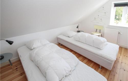 a white bedroom with two beds and a window at Lovely Home In Samsø With Wifi in Ballen
