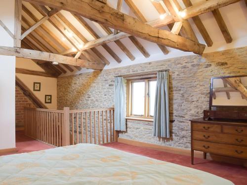 a bedroom with a large bed and a window at Woltons Mill in Much Marcle