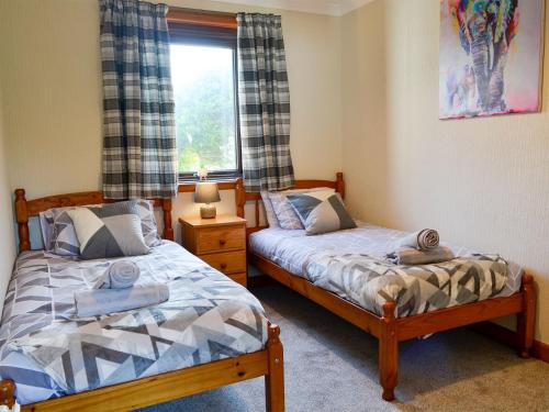Duas camas num quarto com uma janela em The Smithy Of Longcastle em Whauphill