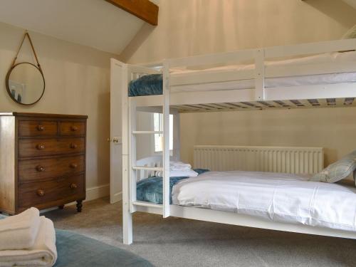 a bedroom with two bunk beds and a dresser at Dewy Lane Farm House in Tansley