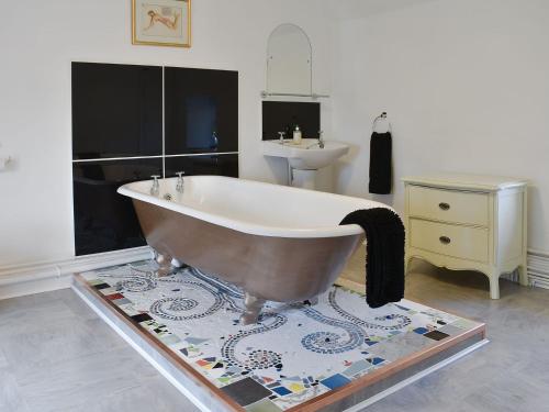 a bath tub in a bathroom with a sink at Dewy Lane Farm House in Tansley