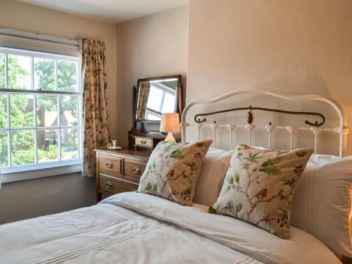 a bedroom with a bed and a mirror and a window at Hambleton House in Malton