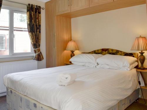 a bedroom with a large white bed with two lamps at Lodge G- Uk33093 in Dinnet