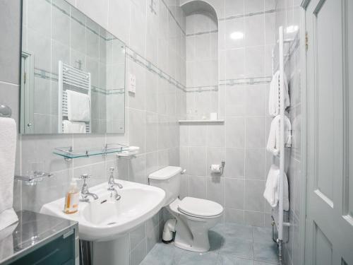a white bathroom with a toilet and a sink at Corby Castle - Courtyard - Uk34670 in Great Corby