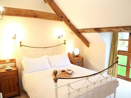 a bedroom with a bed with a white bedspread at Leonard Barn in Stonehouse