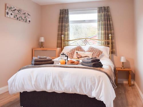 a bedroom with a bed with towels on it at Pheasant Lodge in Staithes