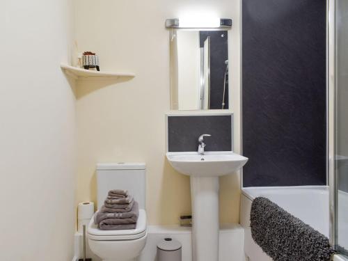 a bathroom with a sink and a toilet and a mirror at Two Dorchester Drive - Uk32036 in Inglewhite