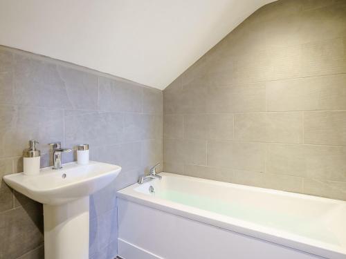 a bathroom with a sink and a bathtub and a bath tub at Ty Godro - Uk12745 in Acrefair
