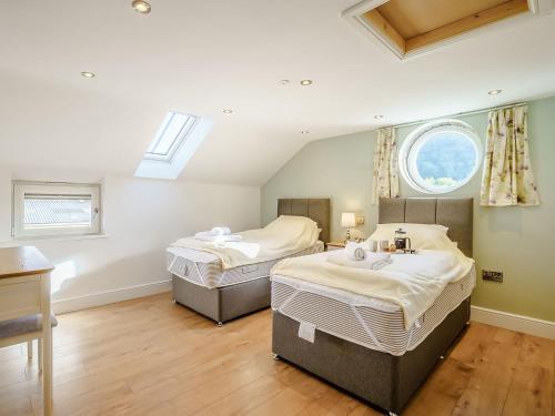 two twin beds in a room with a window at Ty Godro - Uk12745 in Acrefair