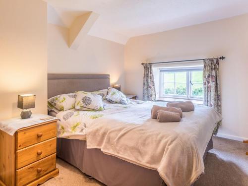 a bedroom with a large bed and a window at Well Farm Cottage - Uk11879 in North Tamerton
