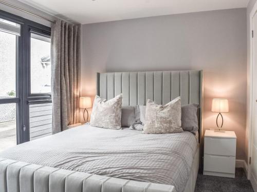 a bedroom with a large bed with white pillows at Woodgate Cottage in Dalton in Furness