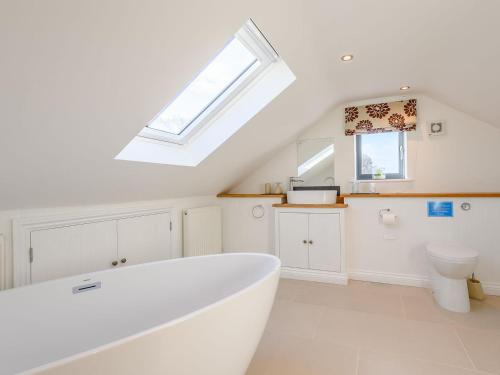 a white bath tub in a bathroom with a window at The Lodge in Upton Bishop