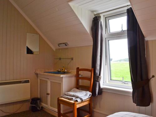 una stanza con lavandino, finestra e sedia di Cuillin View House - Uk12528 ad Arisaig
