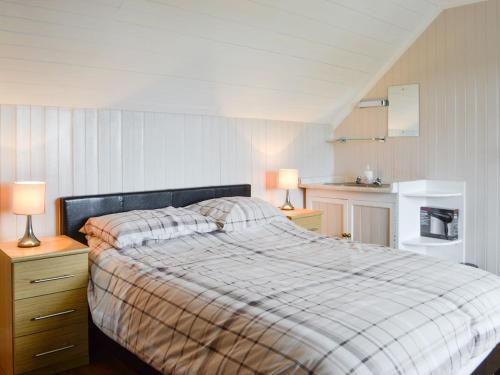 a bedroom with a bed with two lamps and a kitchen at Cuillin View House - Uk12528 in Arisaig