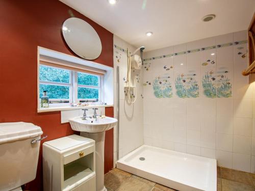 a bathroom with a sink and a toilet and a shower at Highlands Farmhouse in Dallington