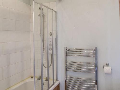 a shower stall in a bathroom with a tub at Sunflower Holiday Cottage in Alford