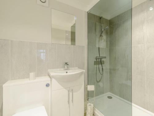 a white bathroom with a sink and a shower at Friars Corner in Richmond