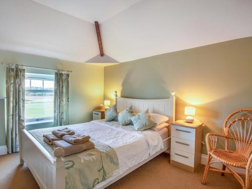 um quarto com uma cama grande e toalhas em The Granary - Uk36124 em Horsington