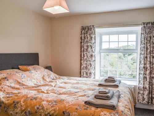 a bedroom with a bed with towels on it at Lower Colvannick in Cardinham