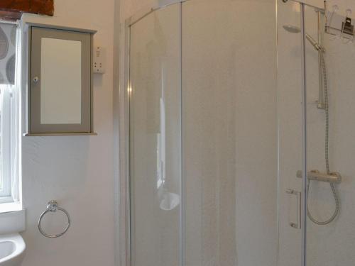 a shower with a glass door in a bathroom at Oxley Cottage in Orby