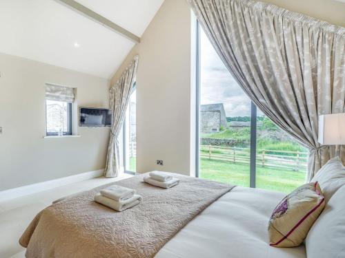 a bedroom with a large window and a bed at Uk34190 - Gowan View in Arkholme