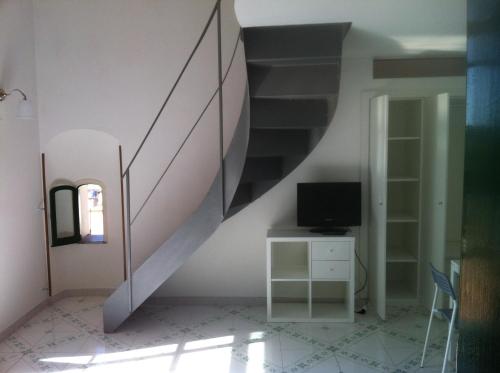 a living room with a staircase and a television at Palazzo Damelio in Scala
