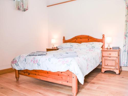 a bedroom with a bed and a night stand with two lamps at Slade Cottage - Uk35027 in Highbray