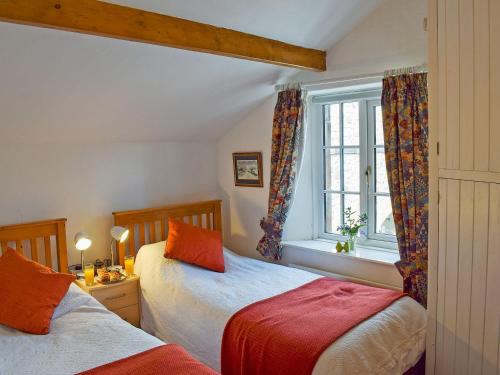 um quarto com 2 camas e uma janela em St Cuthberts Retreat em Wooler