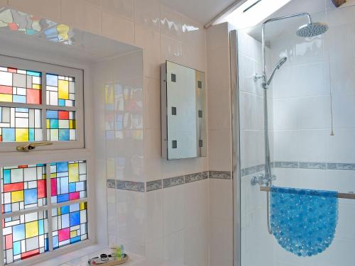 uma casa de banho com um chuveiro e uma porta de vidro em St Cuthberts Retreat em Wooler