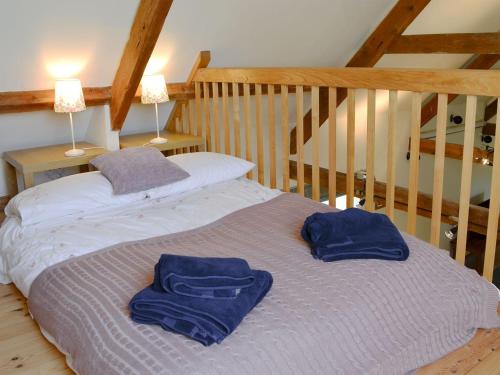 a bed with two blue towels on top of it at Longknowe Barn in Branxton