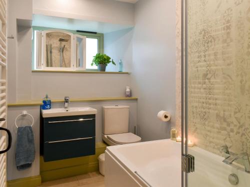 a bathroom with a tub and a toilet and a sink at The Well House in Starbotton