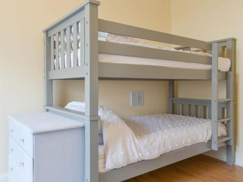 a gray bunk bed with a ladder next to a bedroom at Capstone Reach in Ilfracombe