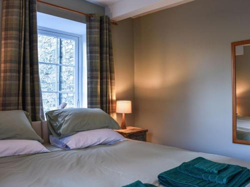 a bedroom with two beds and a window at Starfall in Aysgarth