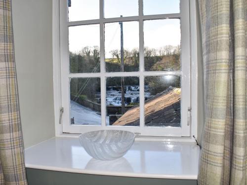una ventana en una habitación con un jarrón sobre una mesa en Starfall en Aysgarth