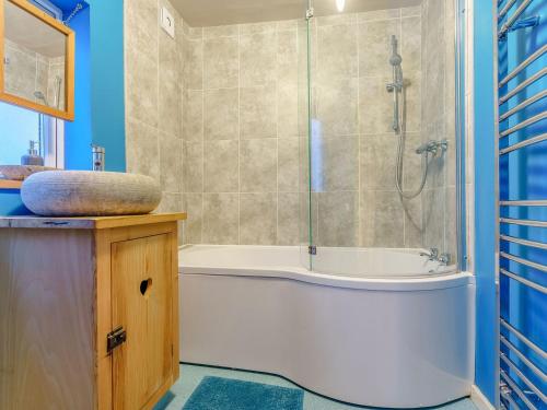 a bathroom with a shower and a tub and a sink at Sayers Yard in Whitby