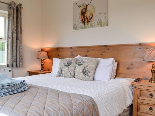 um quarto com uma cama e uma cabeceira em madeira em Powis Castle View em Forden