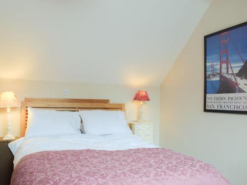 a bedroom with a bed and a tv on a wall at Kuliguni in Ross on Wye