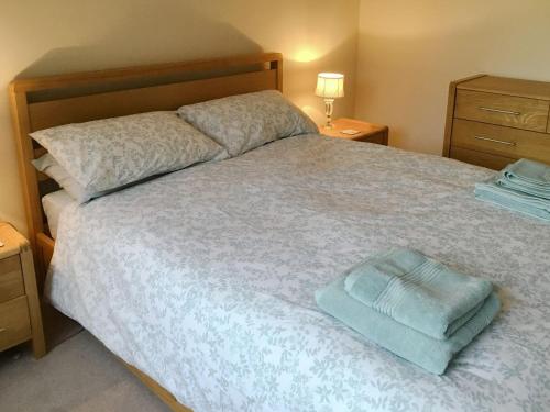 ein Schlafzimmer mit einem Bett und einem blauen Handtuch darauf in der Unterkunft Hedgeways in Fordham