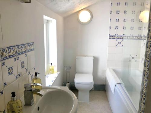 a bathroom with a sink and a toilet and a tub at Summerland Terrace in Kingswear